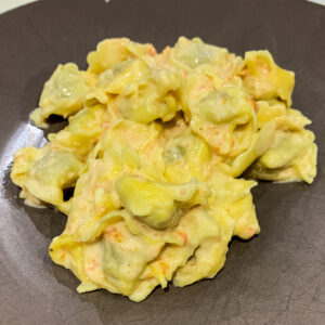 romige tortellini op een grijs bord